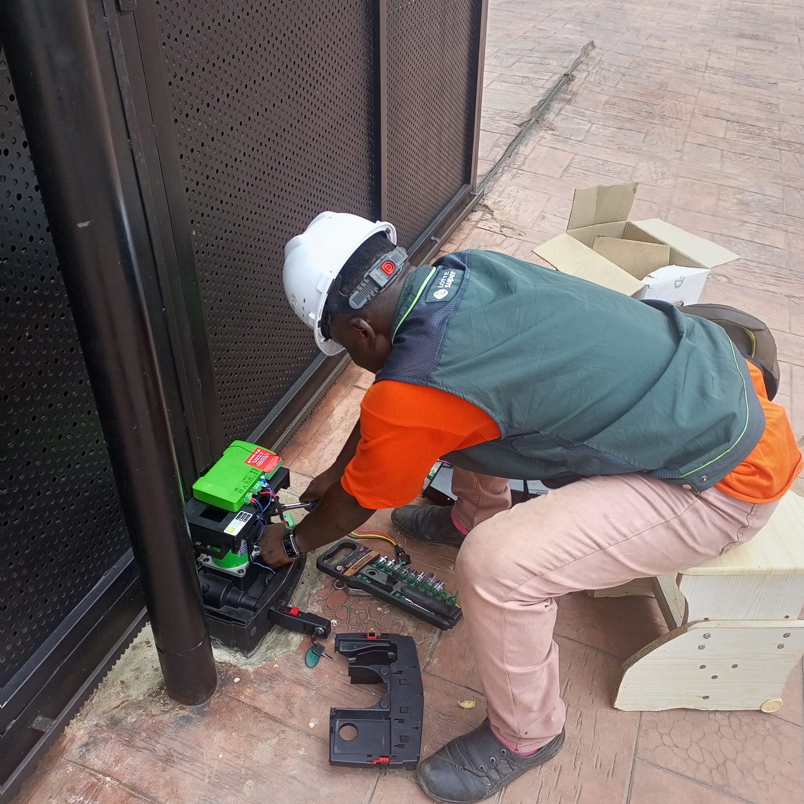 AerixSys technician servicing an automated gate motor control unit during installation
