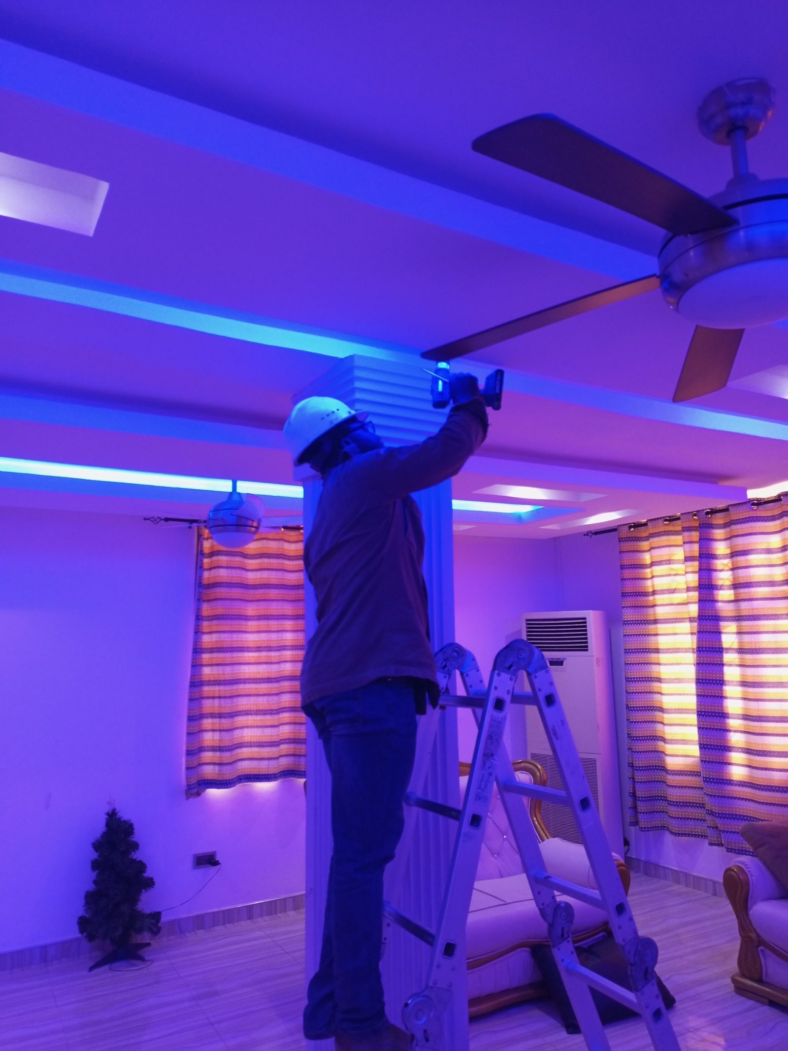 AerixSys technician installing ambient LED ceiling lighting as part of a smart home upgrade