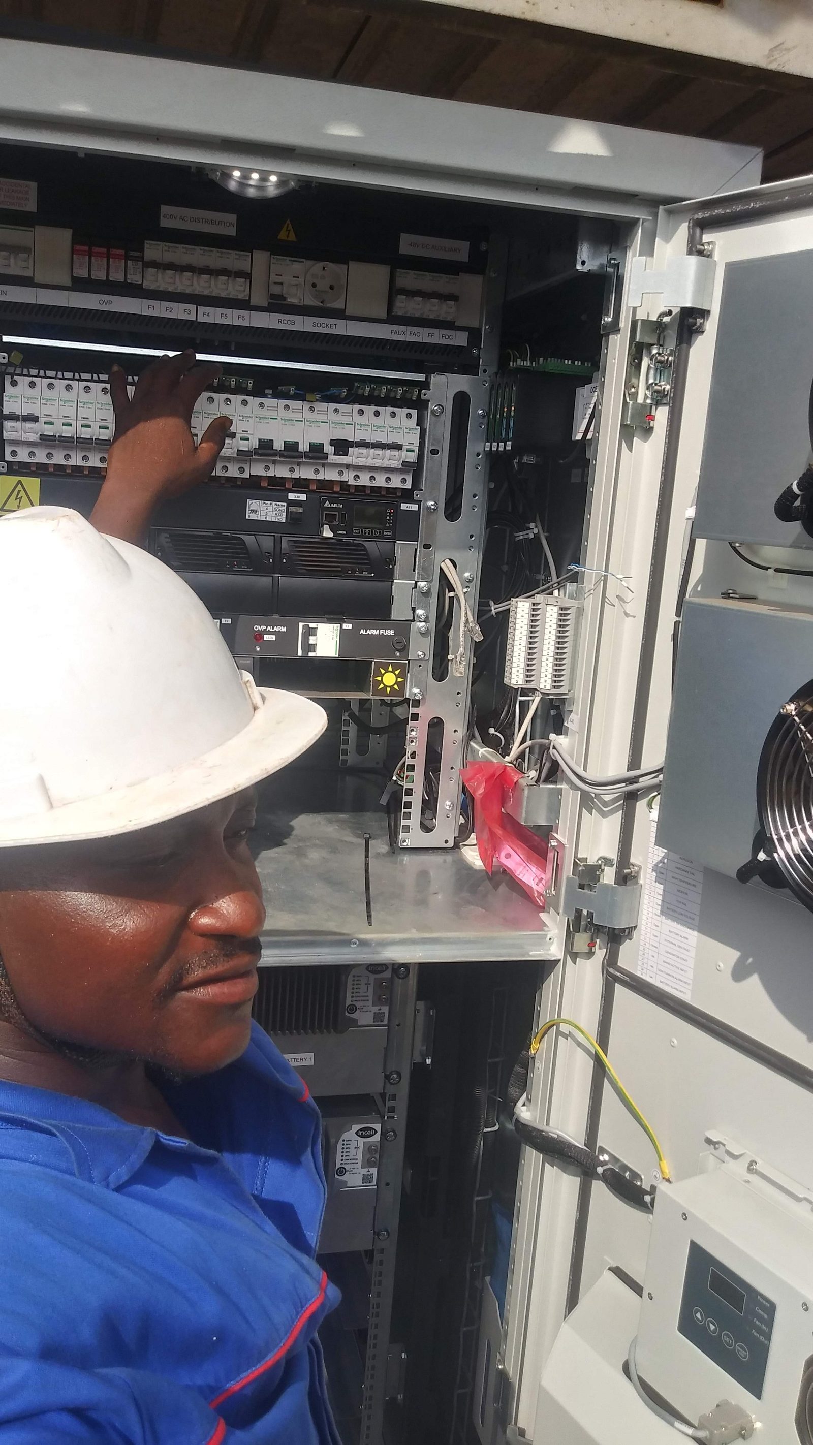 AerixSys technician inspecting a 400V AC distribution and solar power panel on site