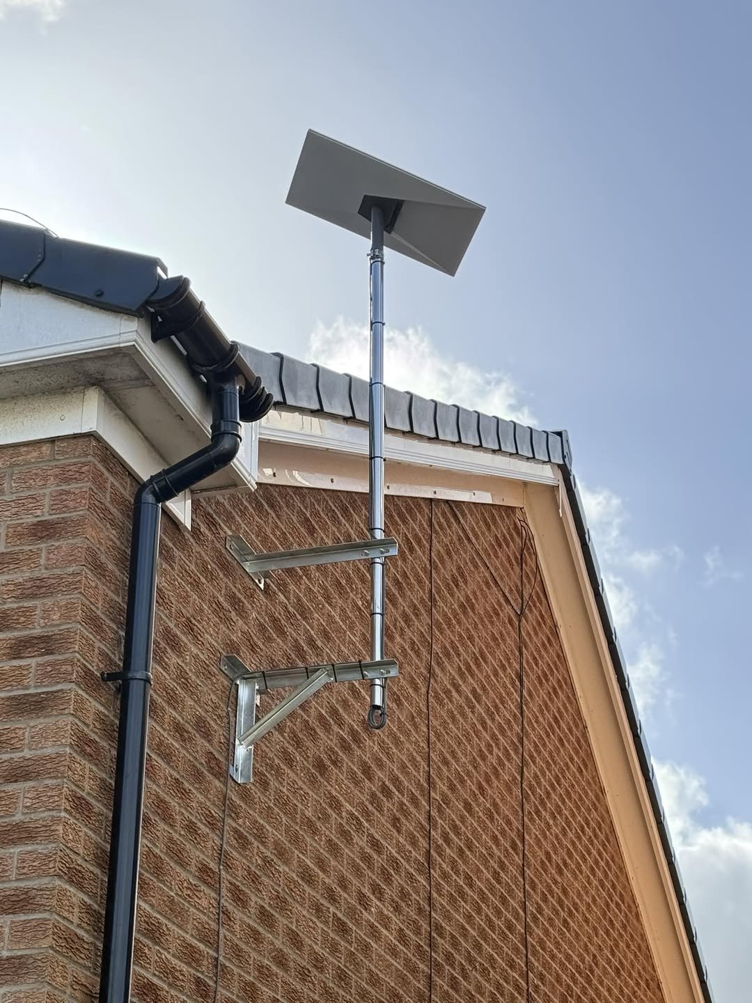 AerixSys Starlink dish mounted on an exterior wall bracket installation