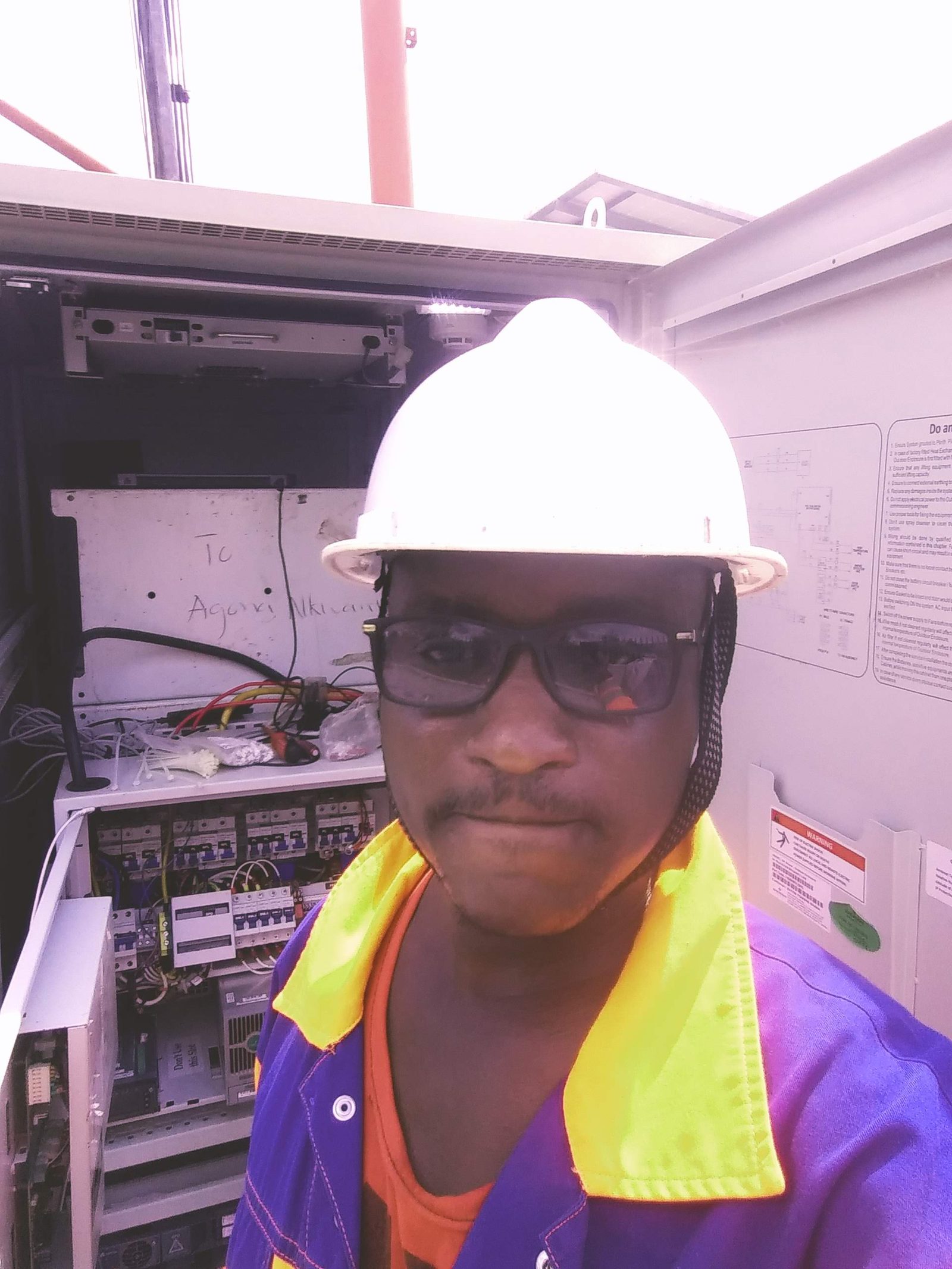 AerixSys technician on site at an open telecom and power equipment cabinet during installation